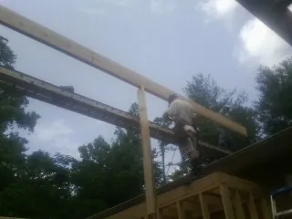 Carpenter setting a ridge beam over a new addition frame — Ice Dam Removal by Roofing Brothers in Royal