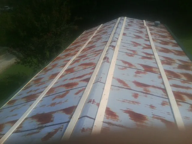 Rusted metal roof panels with new wood purlins before replacement — Storm Damage Roof Repair in Royal by Roofing Brothers