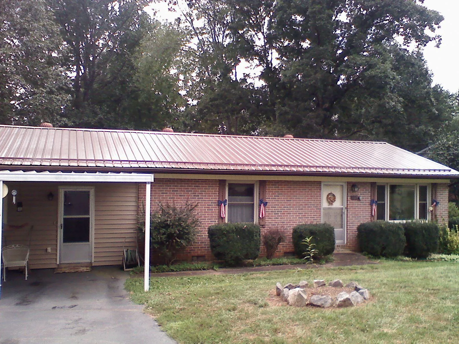 Bronze metal roof and carport on a brick ranch home — Roof Repair work by our crew in Royal